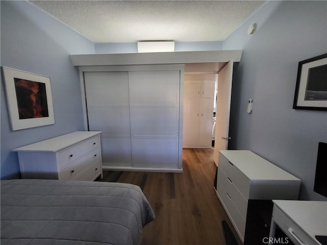 bedroom featuring dark wood-style flooring and a textured ceiling