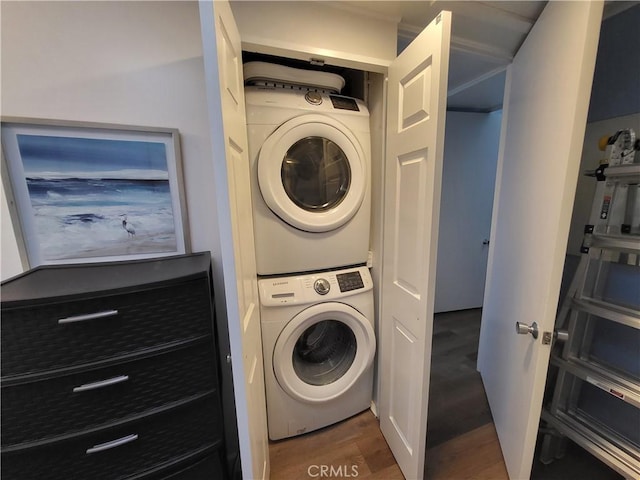 washroom featuring laundry area, stacked washer / dryer, and wood finished floors