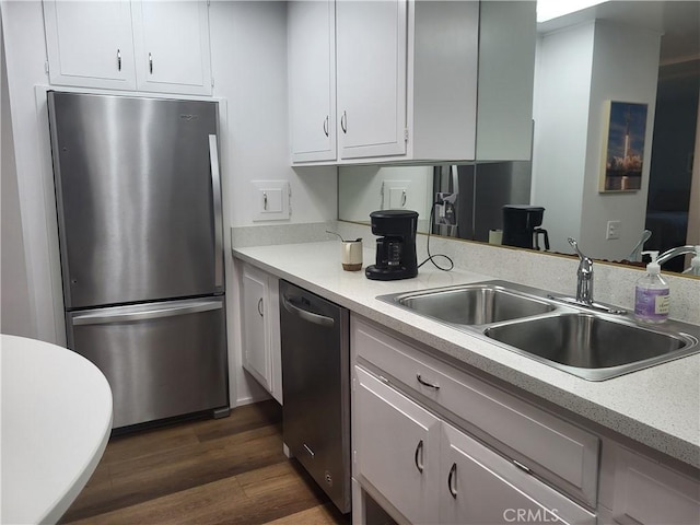 kitchen with white cabinets, stainless steel appliances, a sink, and light countertops