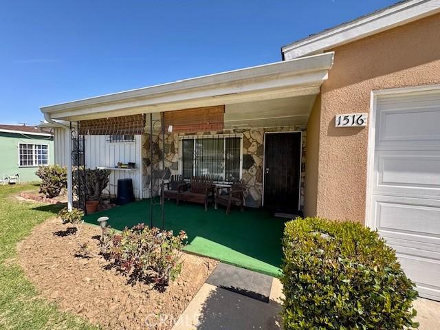 entrance to property with a garage and stucco siding