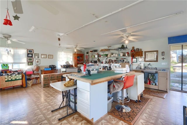 kitchen with a breakfast bar area, open floor plan, light countertops, and light floors