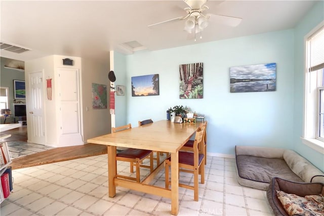 dining room with a healthy amount of sunlight, light floors, ceiling fan, and visible vents