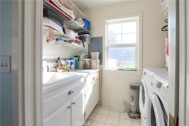 laundry room with cabinet space, a sink, washer and clothes dryer, and light floors