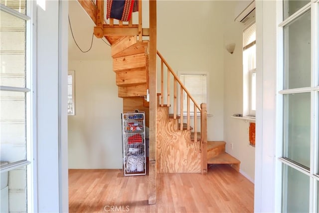 stairway featuring plenty of natural light and wood finished floors