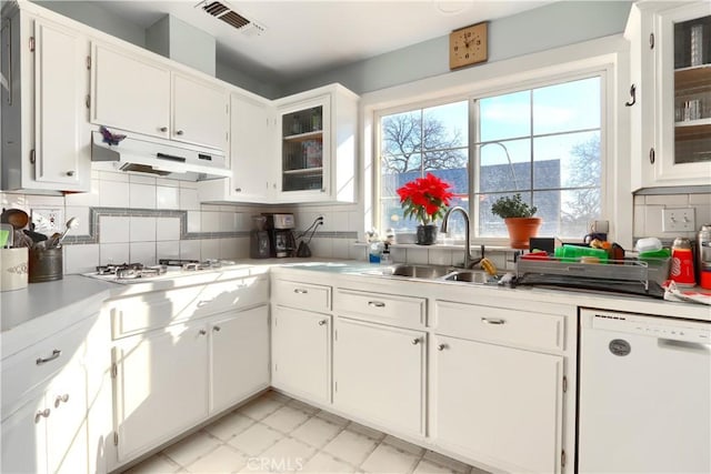 kitchen featuring visible vents, dishwasher, under cabinet range hood, stainless steel gas cooktop, and a sink