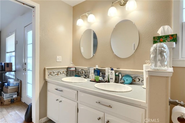 bathroom featuring a healthy amount of sunlight, wood finished floors, and vanity