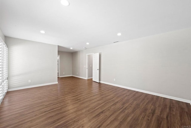 empty room with recessed lighting, baseboards, and dark wood-style flooring