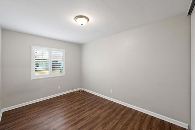 unfurnished room with dark wood-style floors and baseboards