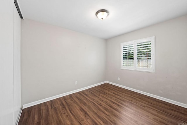 empty room featuring baseboards and wood finished floors