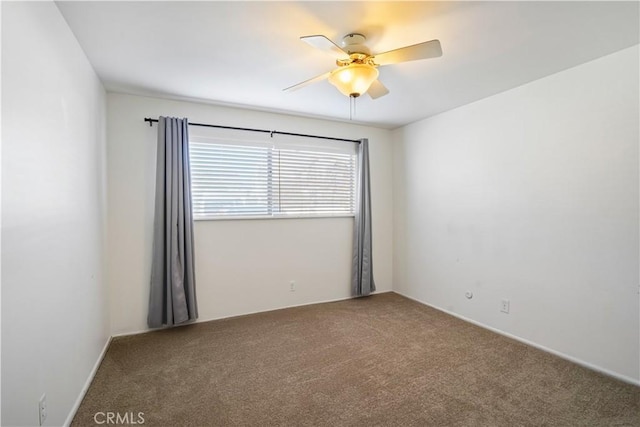 carpeted spare room with a ceiling fan