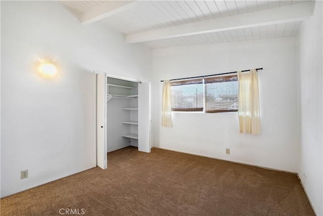 unfurnished bedroom featuring vaulted ceiling with beams, wood ceiling, a closet, and carpet floors