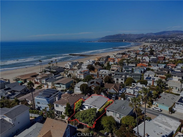 drone / aerial view with a residential view, a water view, and a beach view