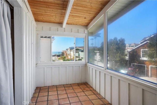 unfurnished sunroom featuring wooden ceiling and beamed ceiling