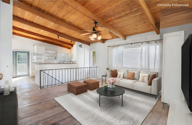 living room with light wood finished floors, beamed ceiling, wooden ceiling, and a ceiling fan