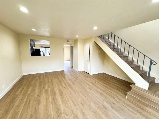 unfurnished living room with recessed lighting, visible vents, stairway, wood finished floors, and baseboards