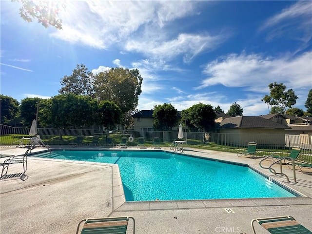 pool with a patio area and fence