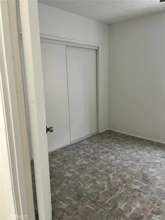 unfurnished bedroom with a closet and a textured ceiling