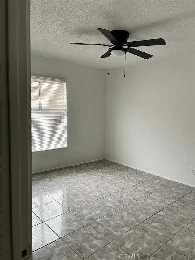 spare room with a ceiling fan and a textured ceiling