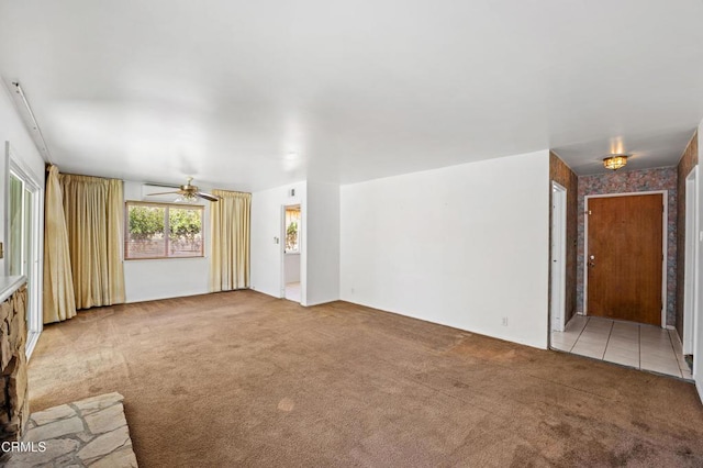 unfurnished living room with carpet and ceiling fan