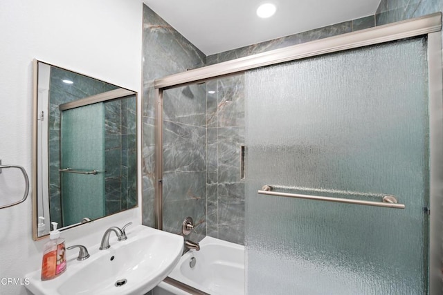 bathroom featuring shower / bath combination with glass door and a sink