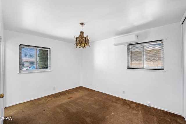 unfurnished room featuring carpet floors, an inviting chandelier, baseboards, and an AC wall unit