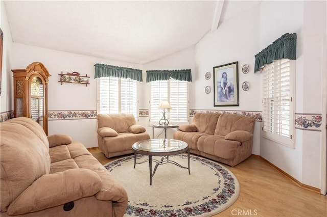 living area with lofted ceiling, light wood-type flooring, and baseboards