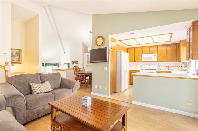 living area featuring lofted ceiling, visible vents, and light wood-style flooring