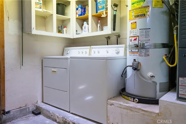 laundry room with laundry area, washing machine and dryer, and water heater