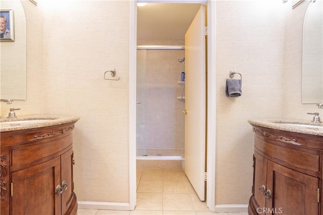 bathroom with tile patterned flooring, a shower stall, two vanities, and a sink