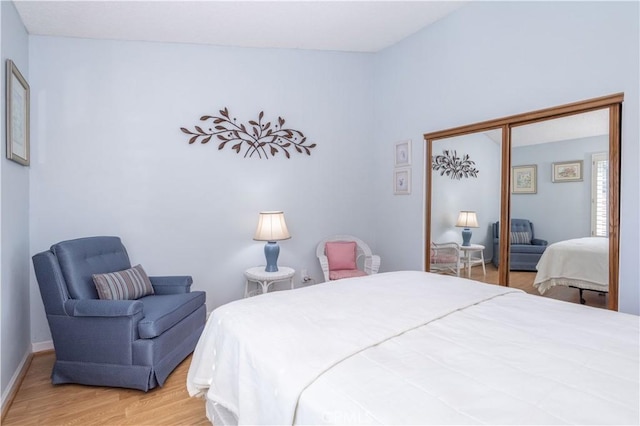 bedroom featuring a closet, baseboards, and wood finished floors