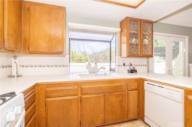 kitchen with light countertops, white appliances, plenty of natural light, and a sink