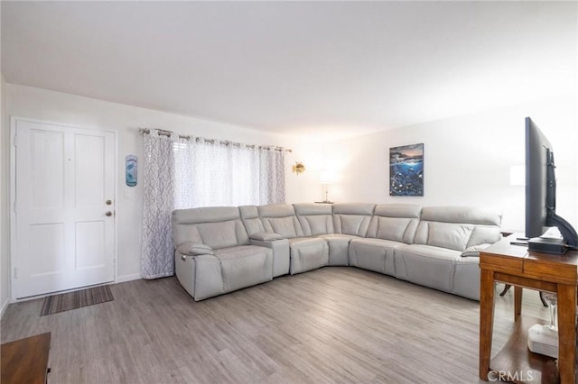 living area with light wood-style flooring and baseboards