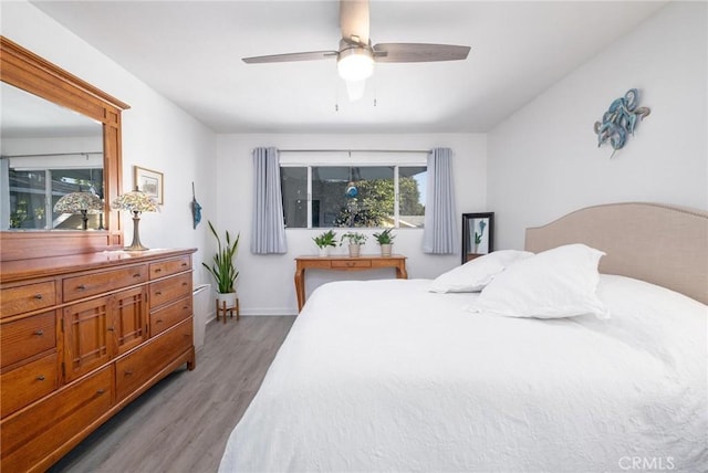 bedroom featuring ceiling fan, wood finished floors, and baseboards