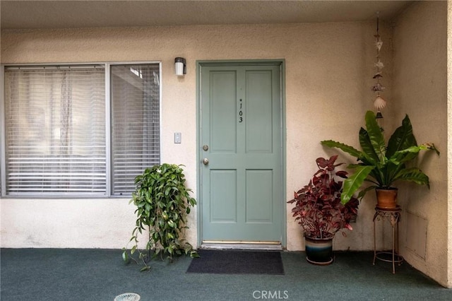 entrance to property featuring stucco siding