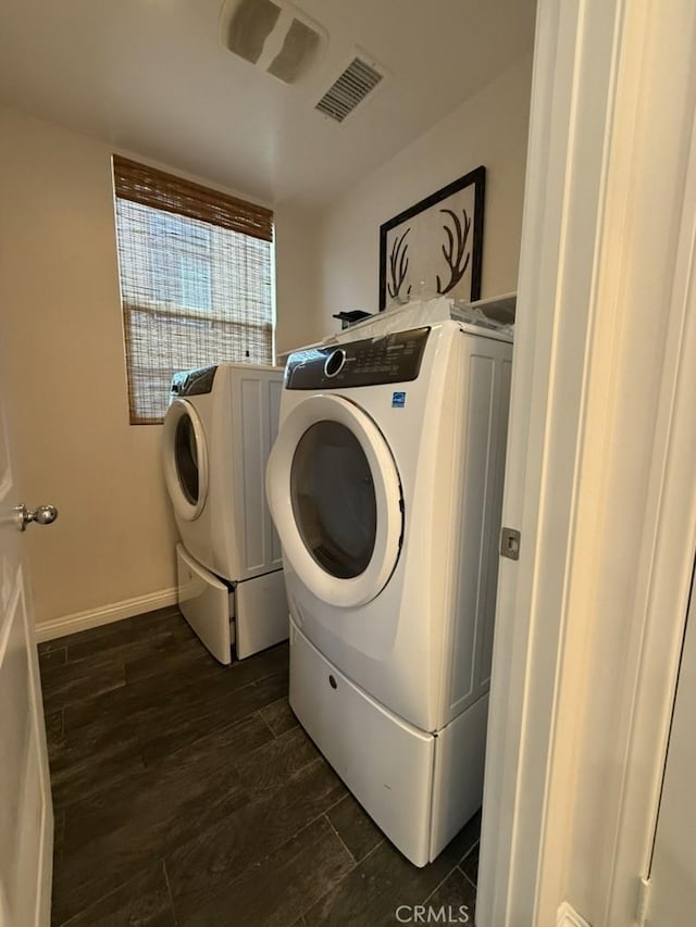 clothes washing area featuring laundry area, visible vents, independent washer and dryer, baseboards, and dark wood-style flooring