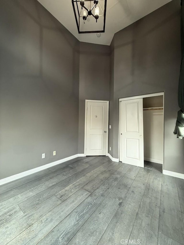 interior space with dark wood-style floors, baseboards, and an inviting chandelier