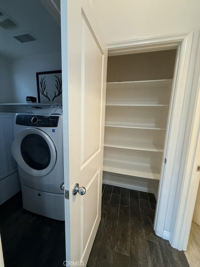 laundry room featuring washer / dryer, wood tiled floor, laundry area, and visible vents