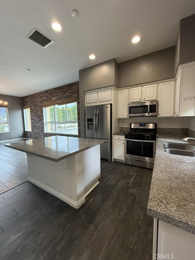 kitchen featuring a sink, visible vents, white cabinets, appliances with stainless steel finishes, and dark wood finished floors