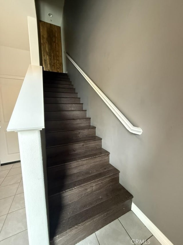 stairs with baseboards and tile patterned floors