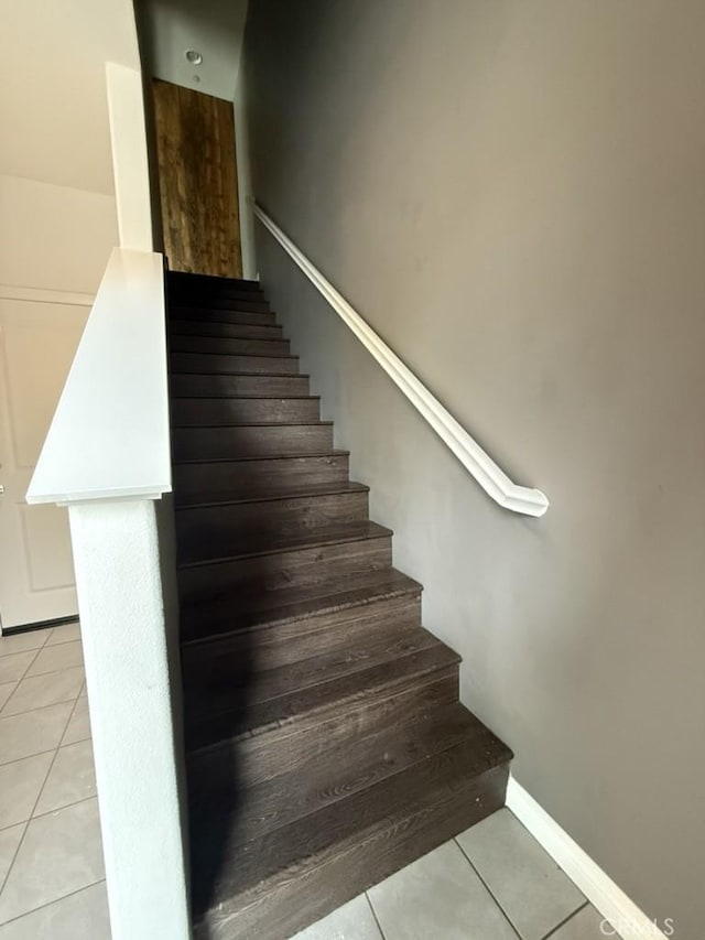 stairway featuring tile patterned floors and baseboards