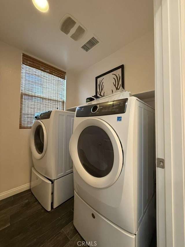 laundry area featuring laundry area, visible vents, dark wood finished floors, and washing machine and clothes dryer