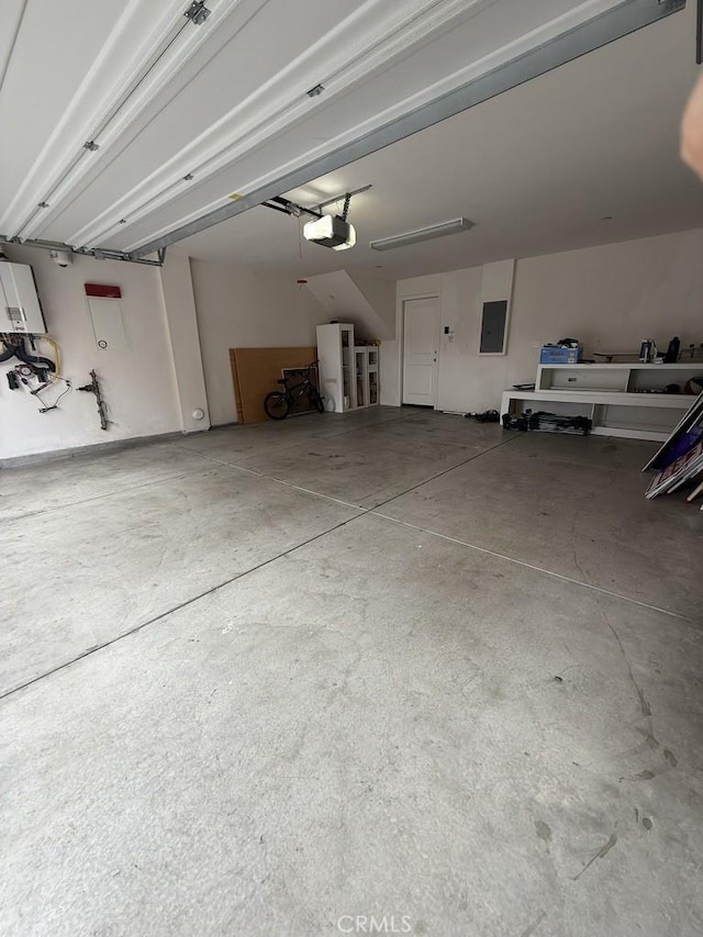 garage with electric panel and a garage door opener