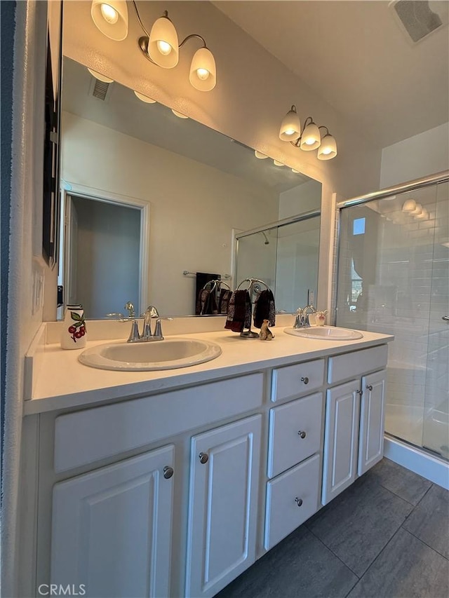 full bathroom with a sink, double vanity, and a stall shower