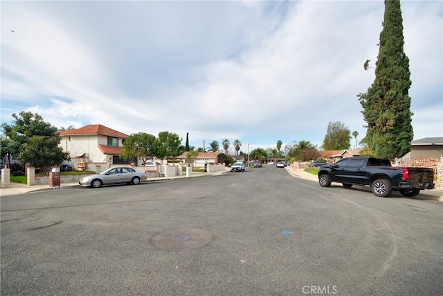 view of street with a residential view, curbs, and sidewalks