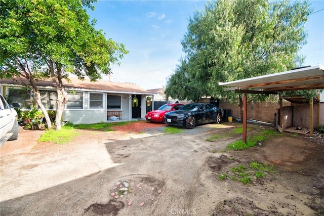 view of front facade with driveway and fence