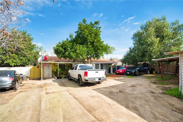 view of front of house with driveway and fence