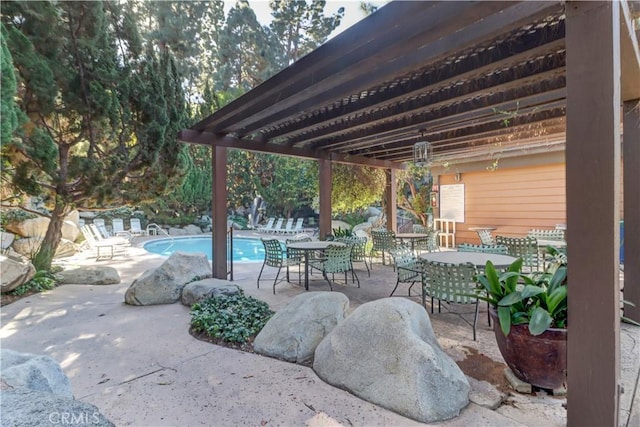 view of patio with outdoor dining area and an outdoor pool