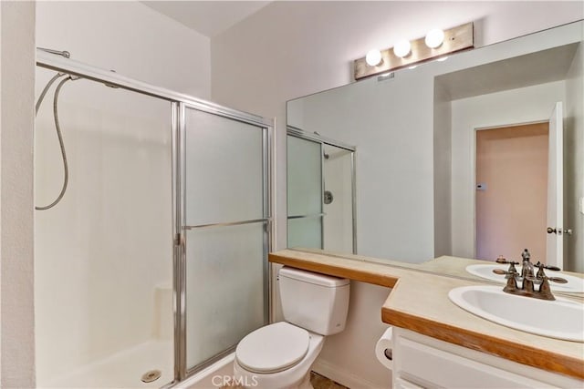 bathroom featuring toilet, a stall shower, and vanity