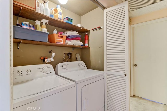 clothes washing area with washer and dryer, laundry area, and light carpet