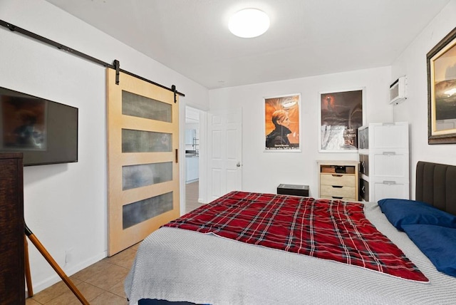 bedroom with tile patterned flooring, baseboards, an AC wall unit, and a barn door